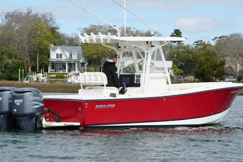 Slide: The Image of 2003 Regulator 26 Forward Seating boat with twin Yamaha 225 engines on a calm waterway. - 4