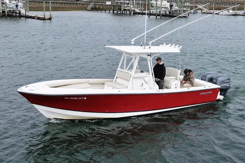 Slide: The Image of 2003 Regulator 26 Forward Seating boat with red hull cruising on water. - 7