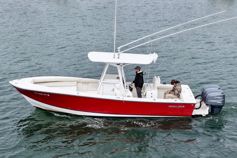 Slide: The Image of 2003 Regulator 26 Forward Seating boat with red hull on open water. - 9