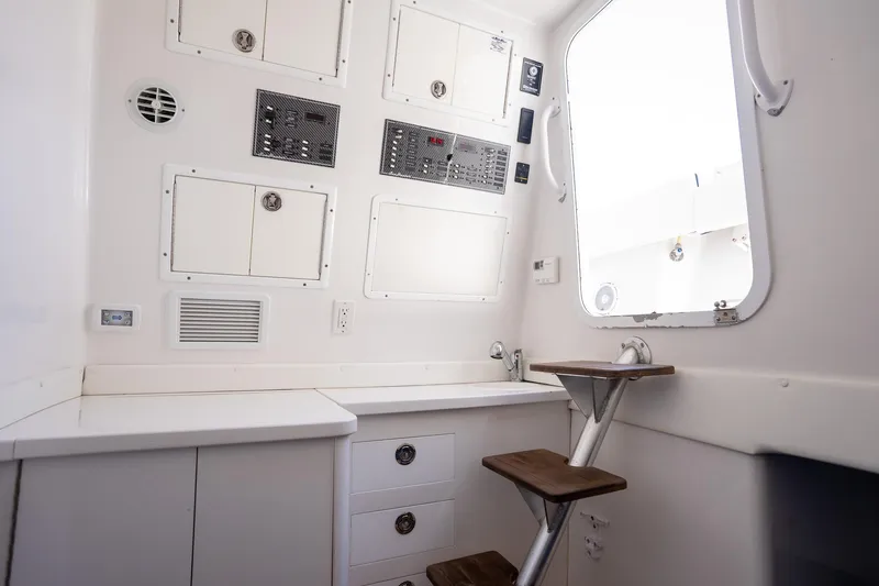 Slide: The Image of Interior of 2016 SeaHunter 45 boat, featuring control panels and wooden steps. - 10