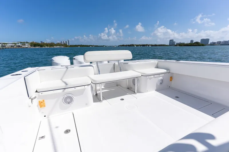 Slide: The Image of 2016 SeaHunter 45 boat deck with seating, overlooking calm blue waters and distant cityscape. - 17