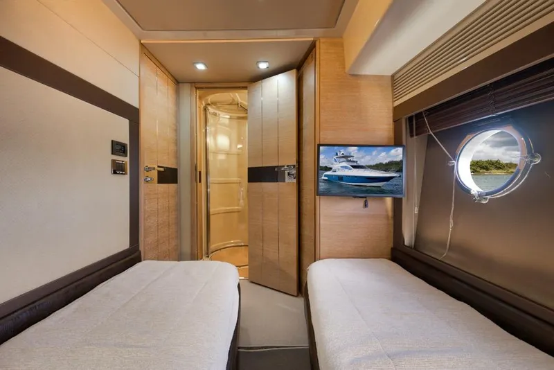 Slide: The Image of Luxurious 2012 Azimut 64 yacht cabin with twin beds, porthole, and TV. - 33