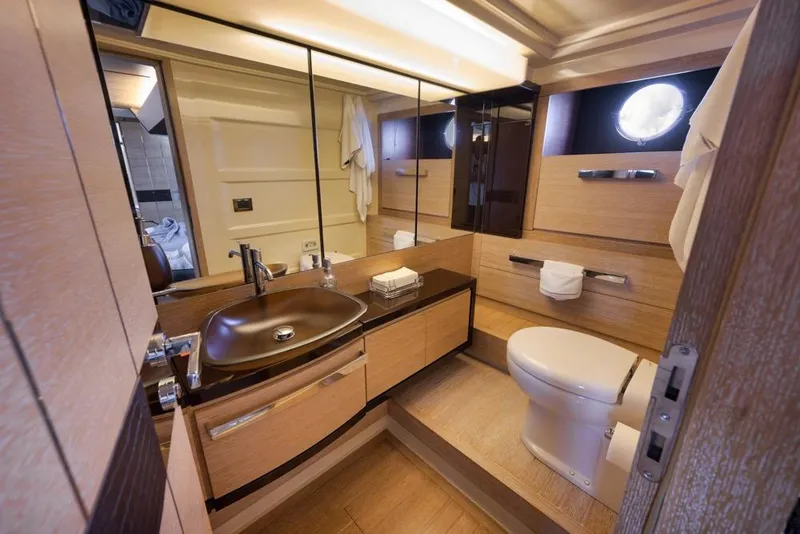 Slide: The Image of Luxurious bathroom interior of a 2012 Azimut 64 yacht, featuring modern fixtures and elegant wood finishes. - 38
