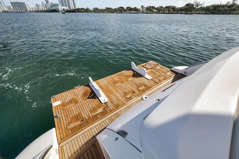 Slide: The Image of Luxury yacht Azimut 64 (2012) with wooden deck, overlooking serene waters and city skyline. - 6