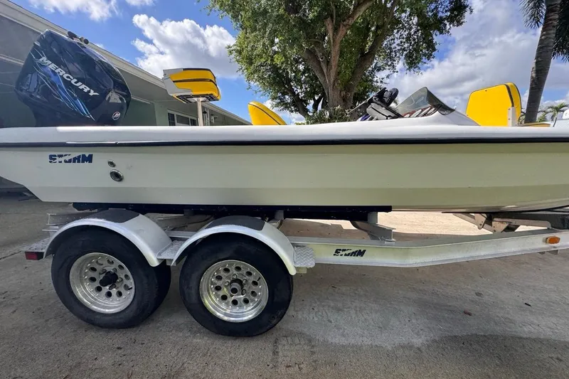 Slide: The Image of 2005 Storm Boats Storm-High Performance on trailer, featuring Mercury engine, parked outdoors. - 13