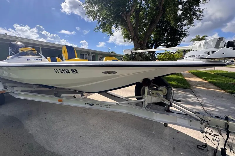 Slide: The Image of 2005 Storm Boats Storm-High Performance on trailer, featuring Minn Kota motor, parked outdoors. - 17