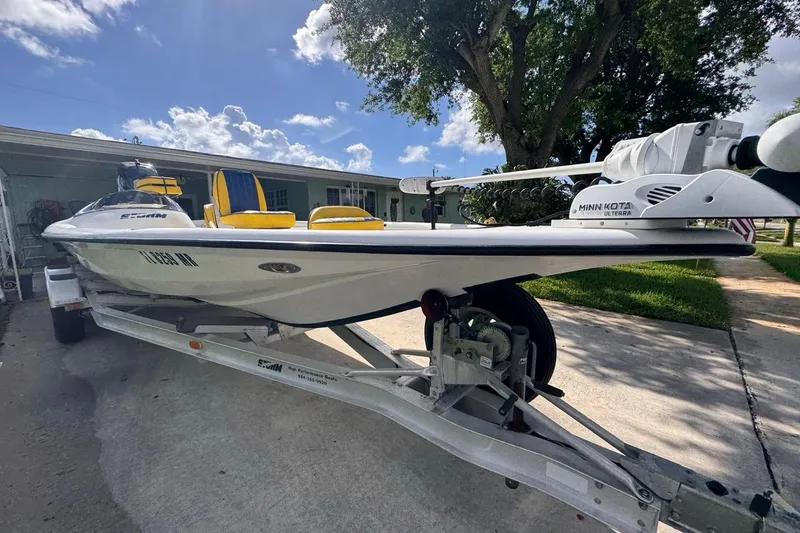 Slide: The Image of 2005 Storm Boats Storm-High Performance on trailer, featuring Minn Kota Ulterra motor, parked outdoors. - 18
