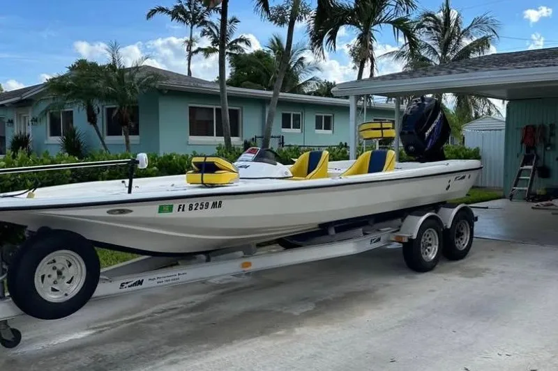 Slide: The Image of 2005 Storm Boats Storm-High Performance on trailer, parked near palm trees under blue sky. - 2