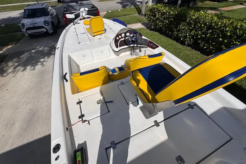 Slide: The Image of 2005 Storm Boats Storm-High Performance with yellow and blue seating, parked on driveway. - 37