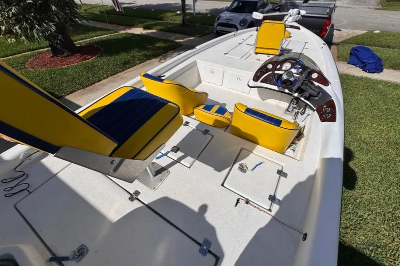 Slide: The Image of 2005 Storm Boats Storm-High Performance with yellow and blue seating, parked on grass. - 38