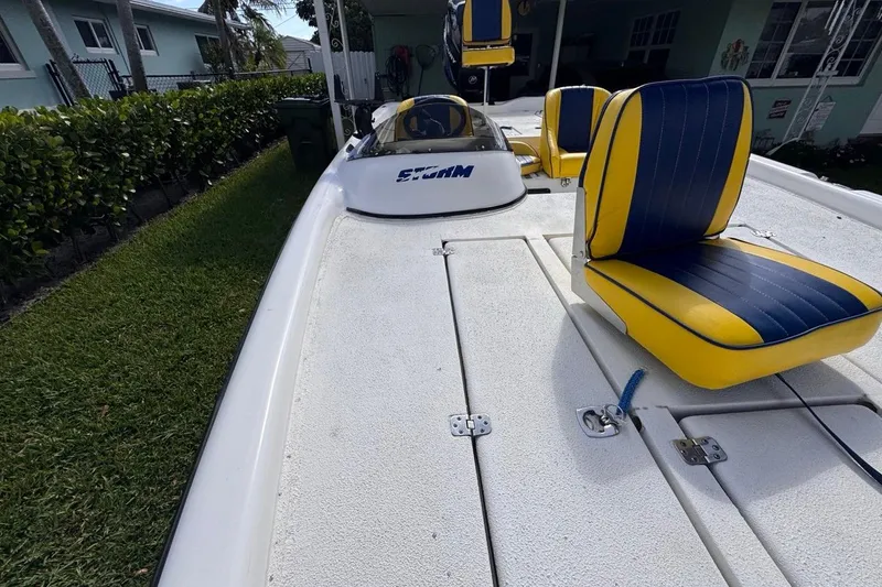 Slide: The Image of 2005 Storm Boats Storm-High Performance with yellow and blue seats, parked on grass. - 56
