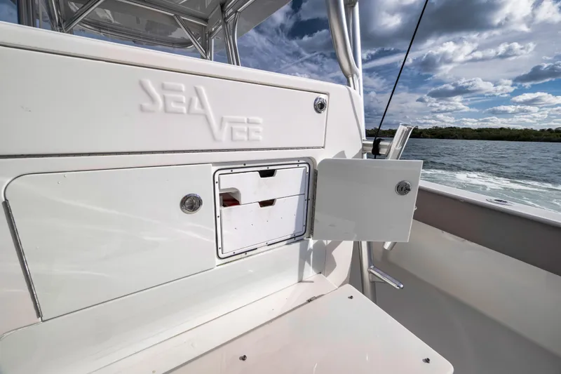 Slide: The Image of 2021 SeaVee 390Z boat interior with storage compartment, ocean view, and cloudy sky. - 14
