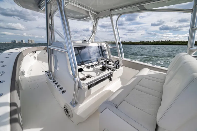 Slide: The Image of 2021 SeaVee 390Z boat interior with helm, steering wheel, and seating on open water. - 15