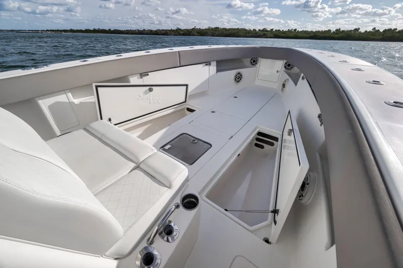 Slide: The Image of 2021 SeaVee 390Z boat interior with open storage compartments, white seating, and ocean view. - 19