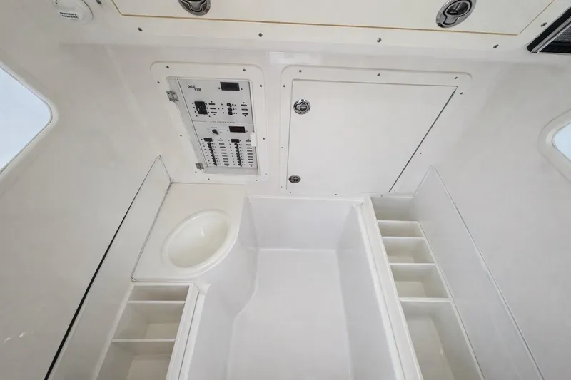 Slide: The Image of 2021 SeaVee 390Z interior with control panel, storage compartments, and sink. - 21