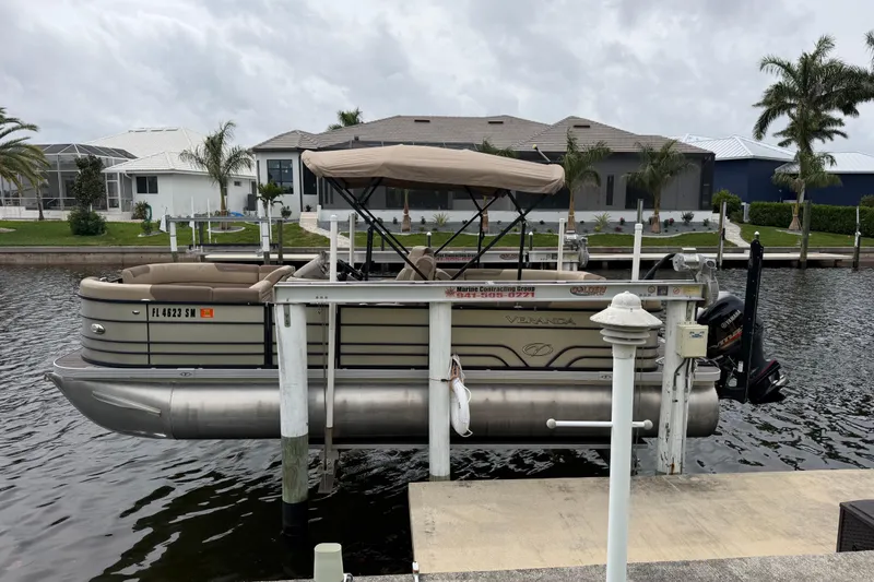 The Image of 2020 Veranda Relax VR 22 RC pontoon boat docked by waterfront homes. - 0