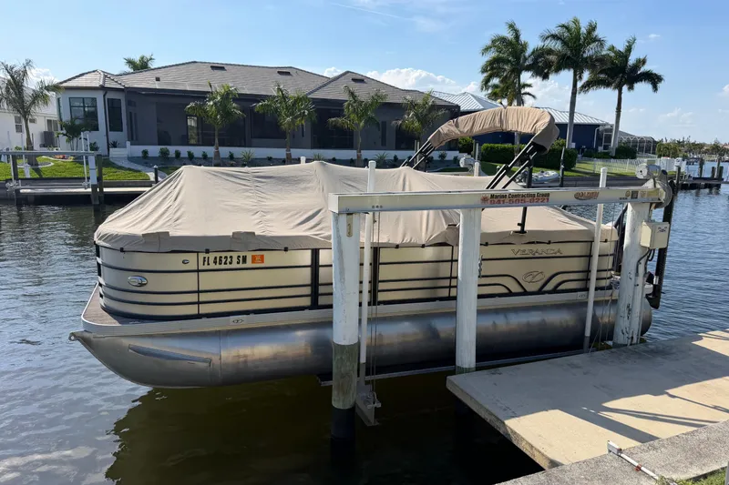 Slide: The Image of 2020 Veranda Relax VR 22 RC pontoon boat docked by waterfront homes. - 21