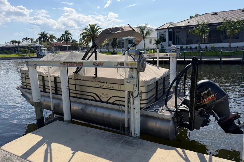 Slide: The Image of 2020 Veranda Relax VR 22 RC pontoon boat docked with Yamaha outboard motor. - 22