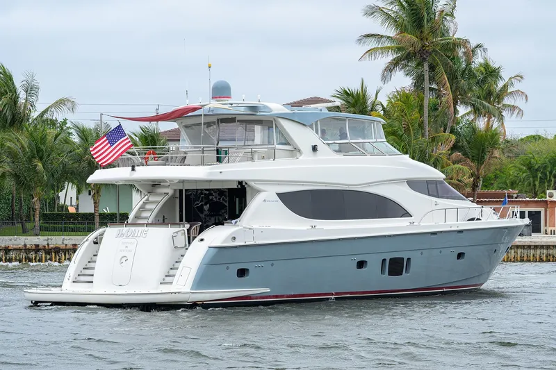 The Image of 2013 Hatteras 80 Motor Yacht cruising near palm trees and waterfront homes. - 0
