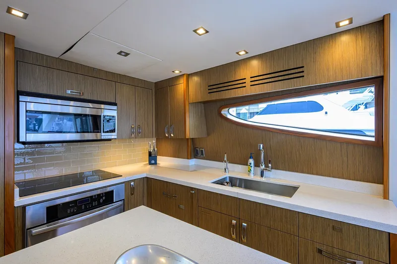 Slide: The Image of Modern kitchen interior on 2013 Hatteras 80 Motor Yacht with sleek appliances and wood cabinetry. - 13