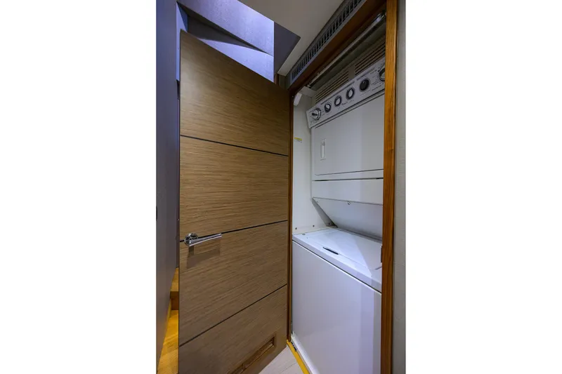 Slide: The Image of Laundry area with stacked washer and dryer on 2013 Hatteras 80 Motor Yacht. - 16