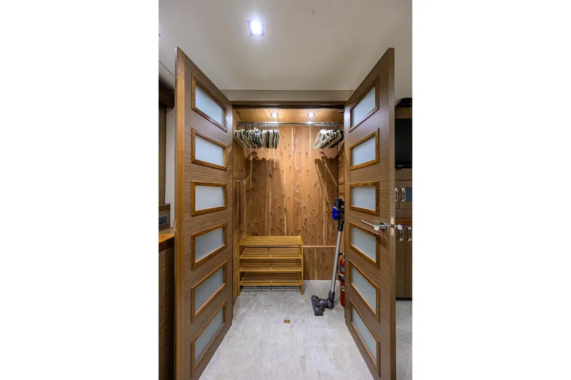 Slide: The Image of Spacious wooden closet interior on 2013 Hatteras 80 Motor Yacht with hangers and storage. - 21