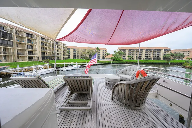 Slide: The Image of Deck of 2013 Hatteras 80 Motor Yacht with lounge chairs and waterfront view. - 44