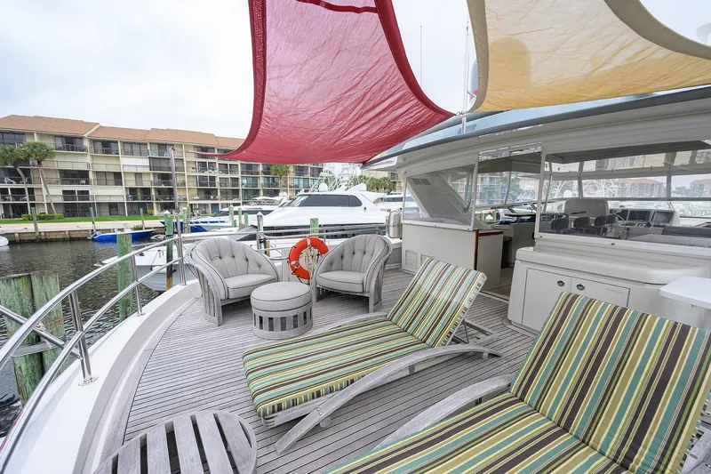 Slide: The Image of Luxurious 2013 Hatteras 80 Motor Yacht deck with striped loungers and seating area. - 45