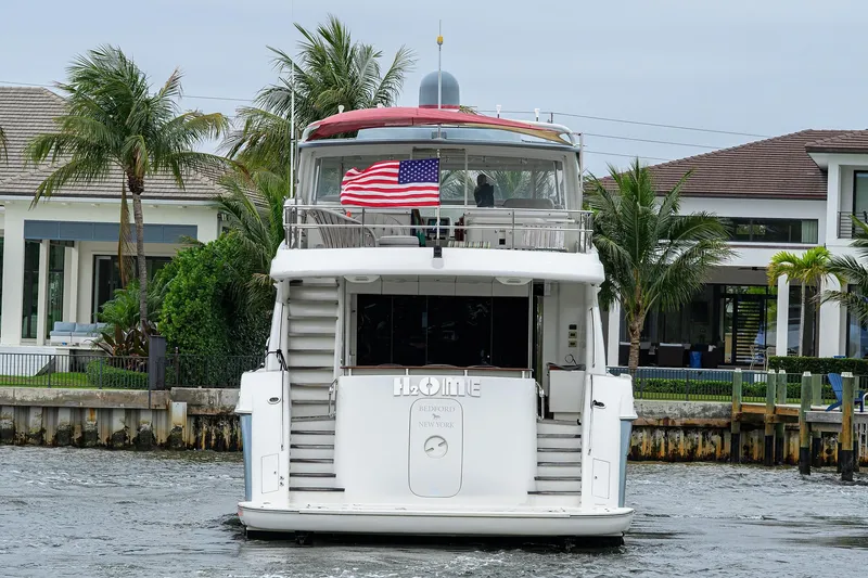 Slide: The Image of 2013 Hatteras 80 Motor Yacht on water, rear view with American flag. - 54