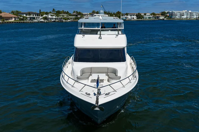 Slide: The Image of 2013 Hatteras 80 Motor Yacht cruising on a sunny day, surrounded by waterfront homes. - 59