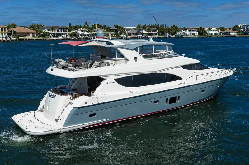 Slide: The Image of 2013 Hatteras 80 Motor Yacht cruising on a sunny day, surrounded by waterfront homes. - 69