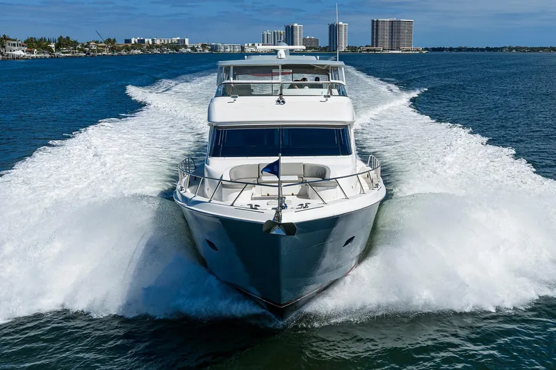 Slide: The Image of 2013 Hatteras 80 Motor Yacht cruising on open water, creating a dynamic wake. - 76