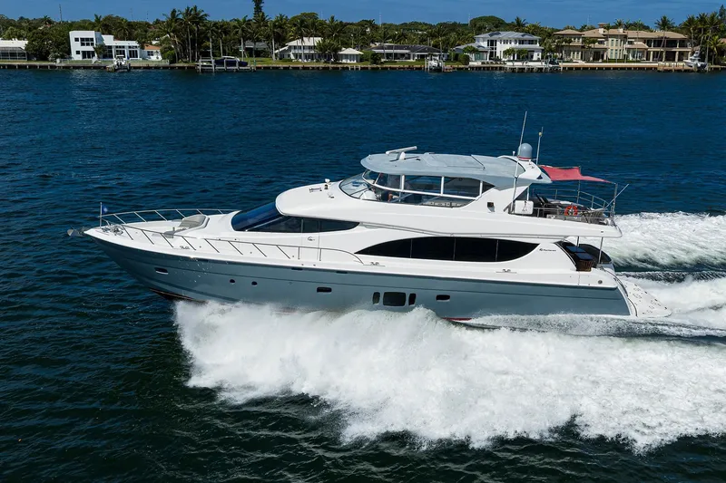 Slide: The Image of 2013 Hatteras 80 Motor Yacht cruising on blue water near luxury waterfront homes. - 82