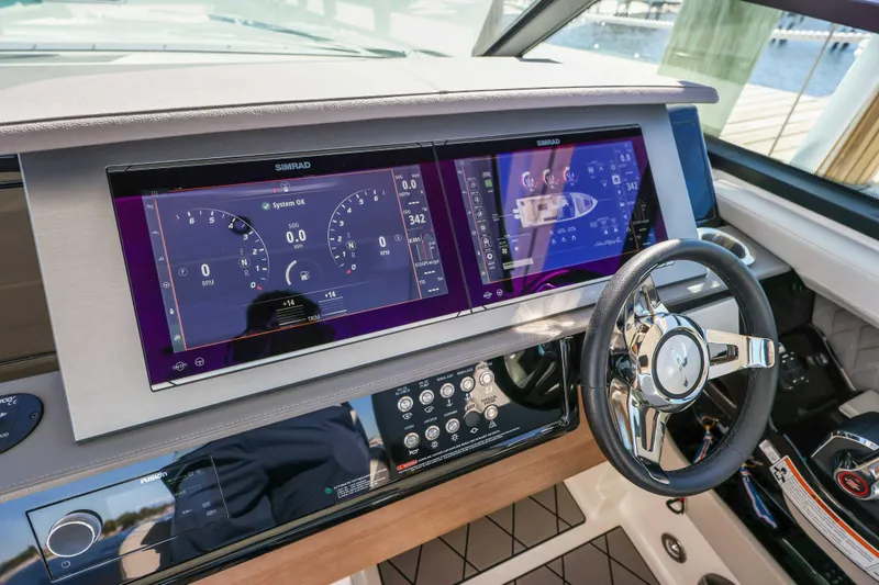 Slide: The Image of 2023 Sea Ray SLX 400 Outboard dashboard with dual Simrad displays and steering wheel. - 35