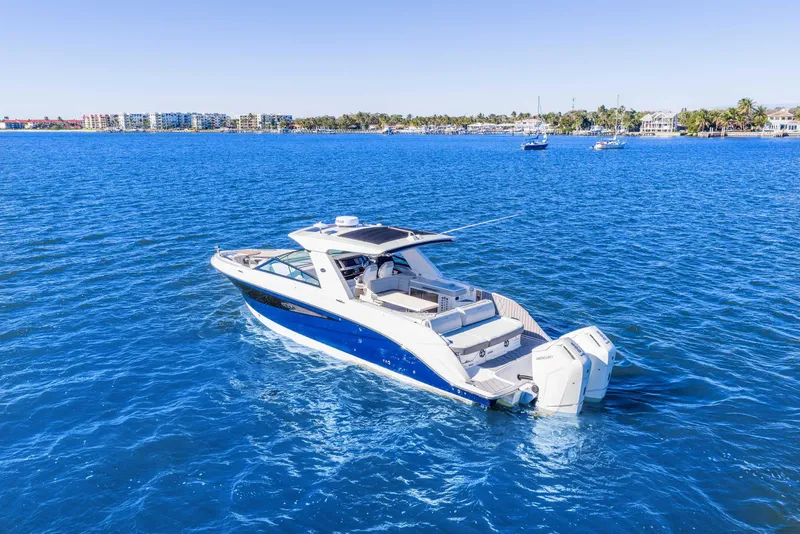 Slide: The Image of 2023 Sea Ray SLX 400 Outboard cruising on clear blue water. - 6