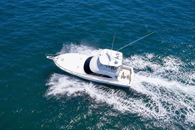 Slide: The Image of Aerial view of a white yacht speeding through blue water, leaving visible wake behind. - 4
