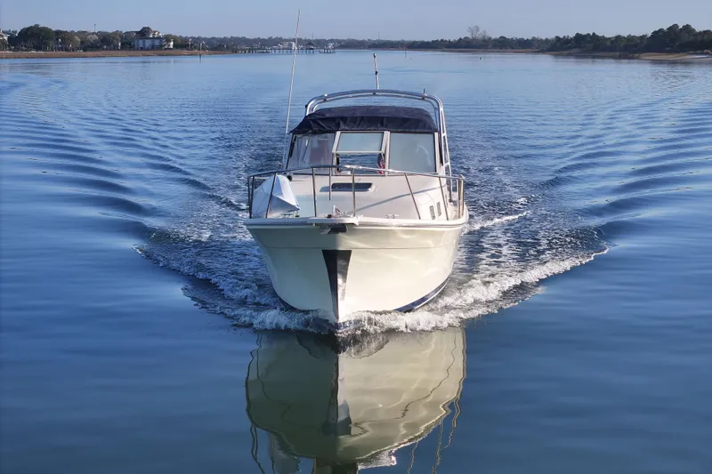 Slide: The Image of 2004 Mainship Pilot 30 Rum Runner cruising on calm water. - 12