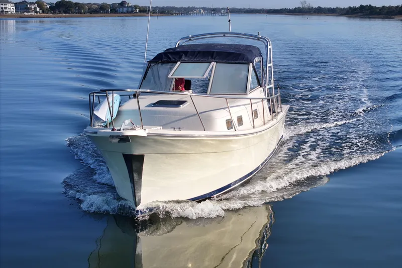 Slide: The Image of 2004 Mainship Pilot 30 Rum Runner cruising on calm water. - 13