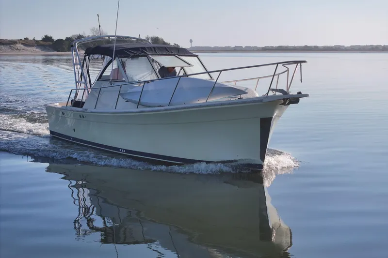 Slide: The Image of 2004 Mainship Pilot 30 Rum Runner cruising on calm waters. - 14