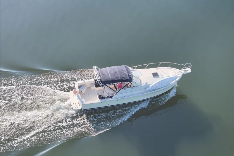 Slide: The Image of 2004 Mainship Pilot 30 Rum Runner cruising on calm water, aerial view. - 15