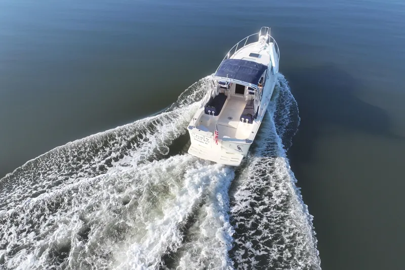 Slide: The Image of 2004 Mainship Pilot 30 Rum Runner cruising on calm waters, aerial view. - 17