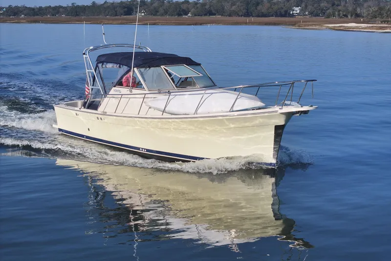 Slide: The Image of 2004 Mainship Pilot 30 Rum Runner cruising on calm waters. - 18
