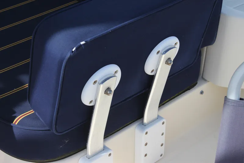 Slide: The Image of 2004 Mainship Pilot 30 Rum Runner seat detail with blue upholstery and metal brackets. - 22