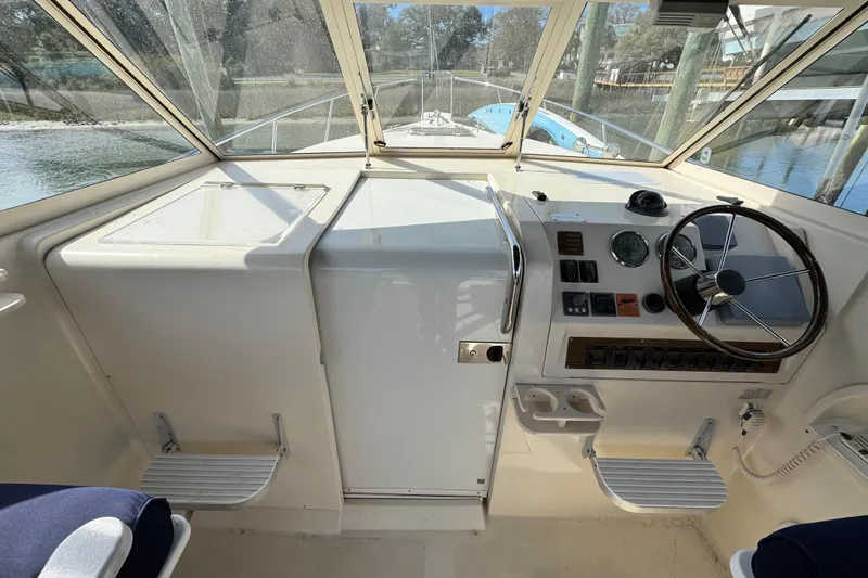 Slide: The Image of 2004 Mainship Pilot 30 Rum Runner helm with steering wheel and control panel. - 34