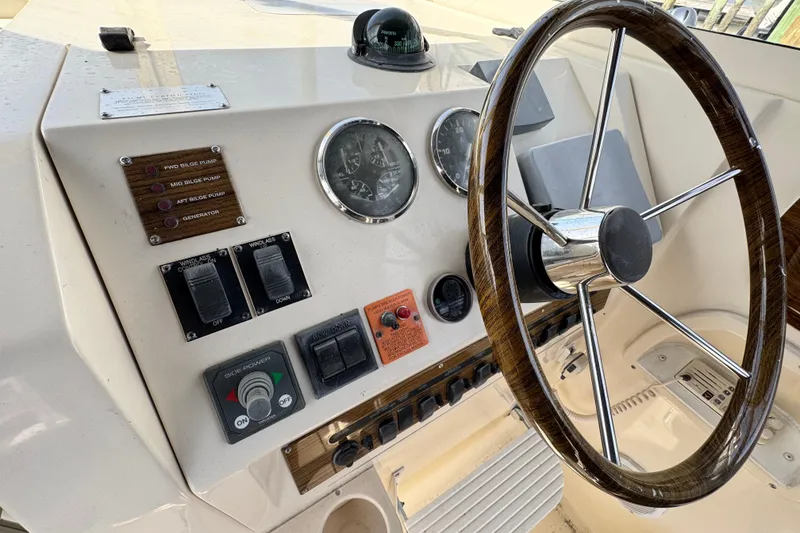 Slide: The Image of 2004 Mainship Pilot 30 Rum Runner helm with gauges, controls, and wooden steering wheel. - 35