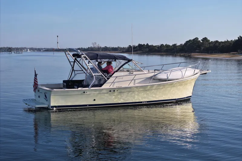 Slide: The Image of 2004 Mainship Pilot 30 Rum Runner cruising on calm waters, side view. - 4
