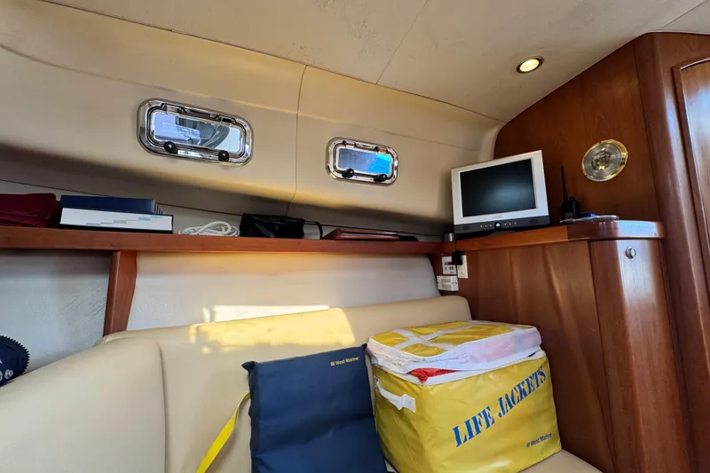 Slide: The Image of Interior of 2004 Mainship Pilot 30 Rum Runner with life jackets and small TV. - 43