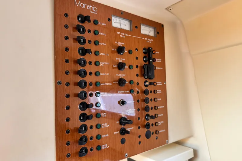 Slide: The Image of Control panel of a 2004 Mainship Pilot 30 Rum Runner boat, featuring various switches and gauges. - 45