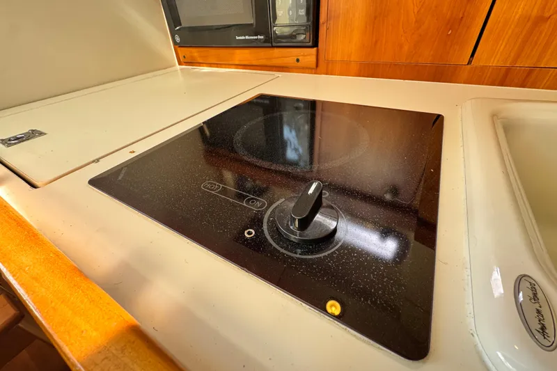 Slide: The Image of 2004 Mainship Pilot 30 Rum Runner kitchen with stovetop and microwave. - 48