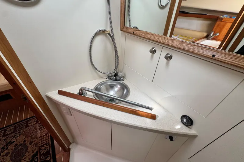 Slide: The Image of 2004 Mainship Pilot 30 Rum Runner bathroom with compact sink and mirror. - 51